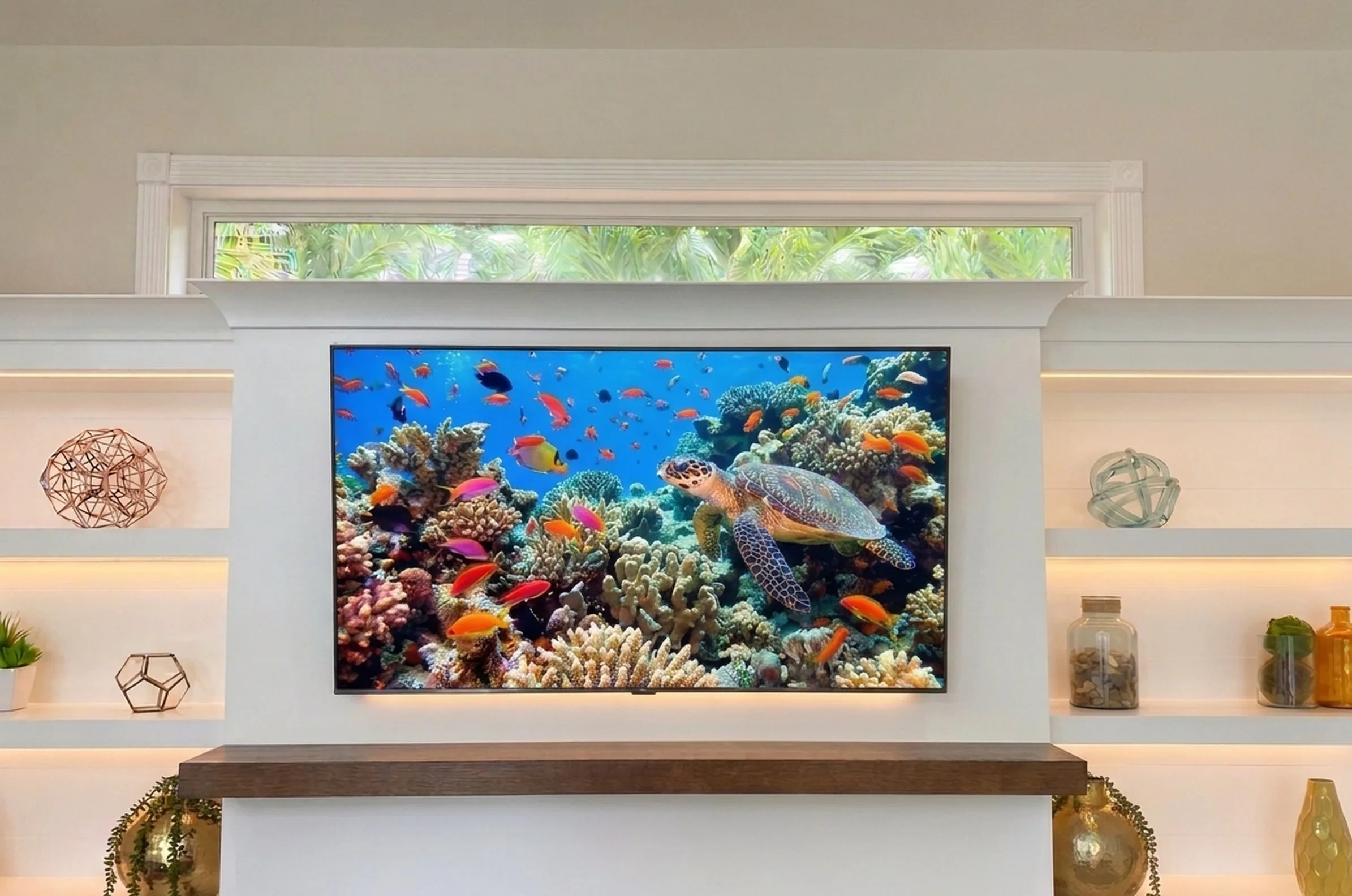 Large TV mounted over a white fireplace with lit built-in shelving and no visible wires, installed by Alsi Pro in South Florida